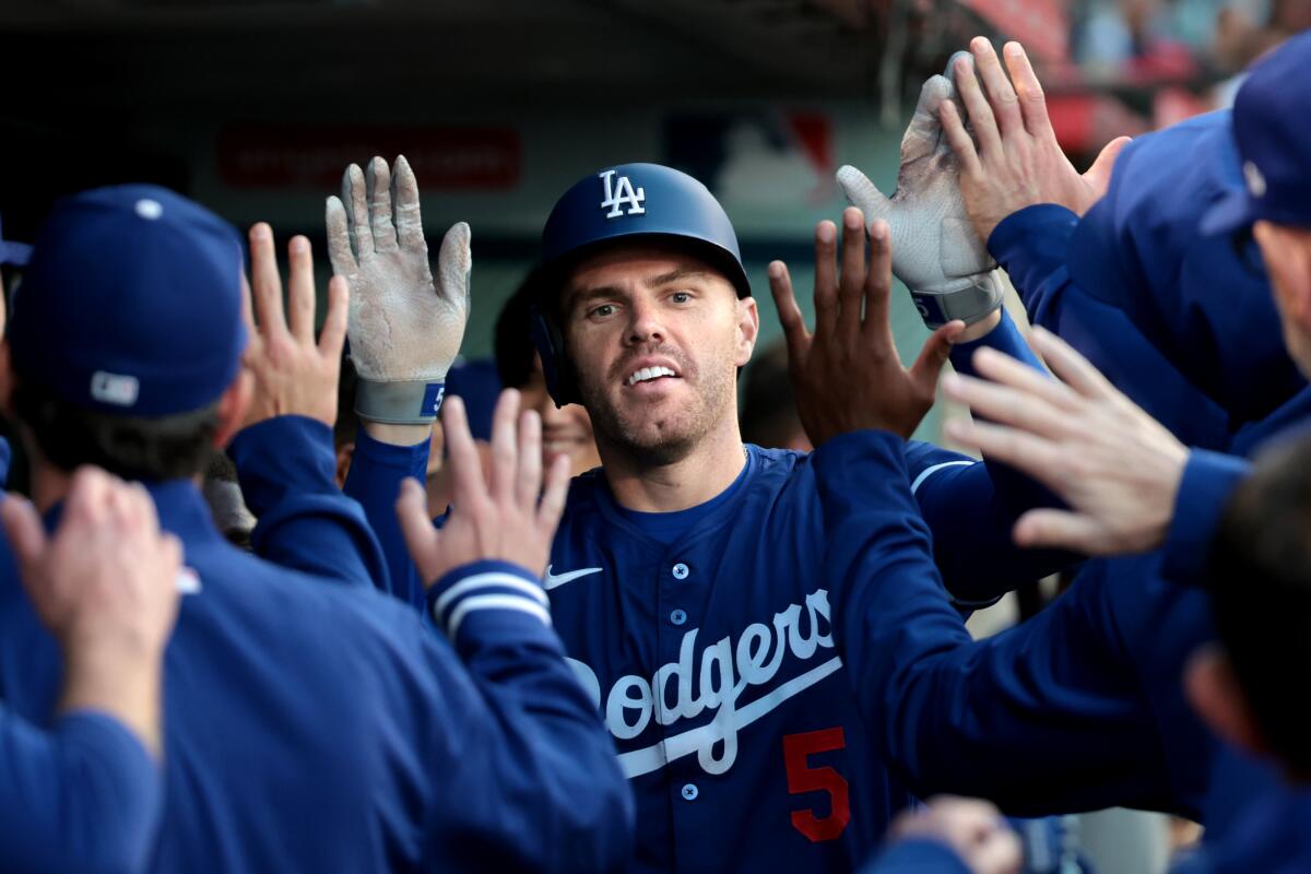 Dodgers star Freddie Freeman celebrates in the dugout after hitting a solo home run against the Angels on Tuesday.