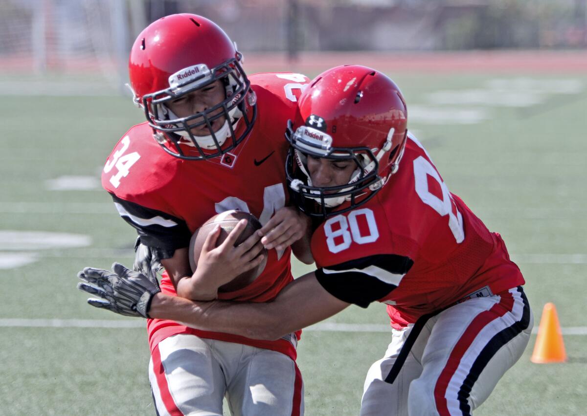 Glendale High School player Mateo Gutierrez, left (LB), and Jonathan Reza, right, (WR, Safety) go through drills during practice at the Nitros stadium, in Glendale on Friday, Aug. 9, 2019.