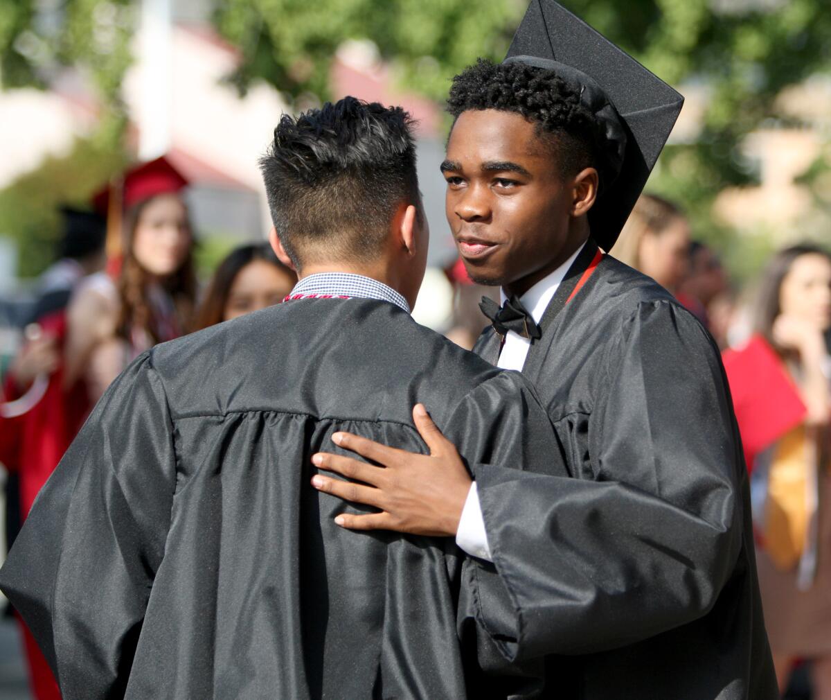 Eli Pajulas, left, gets a hug from friend Ike Nathan before the Glendale High School's commencement ceremony on Wednesday, June 1, 2016.