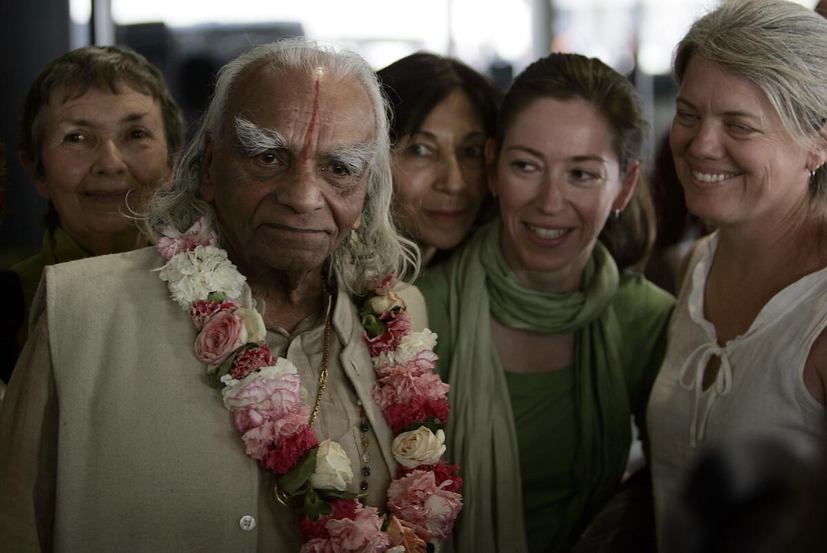 Yoga master B.K.S. Iyengar poses for pictures with fans and followers after arriving at Los Angeles International Airport in 2005.