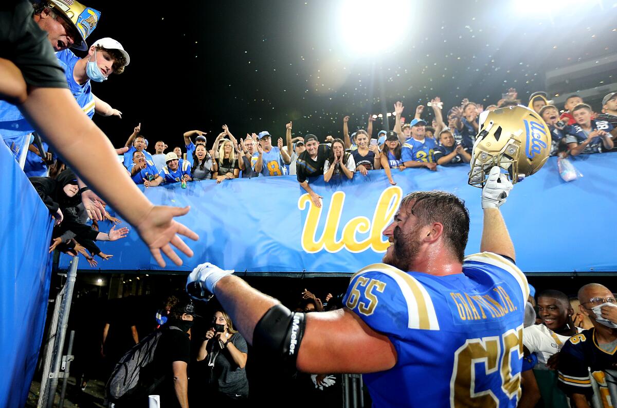 UCLA starting left guard Paul Grattan is cheered by fans after the Bruins beat LSU