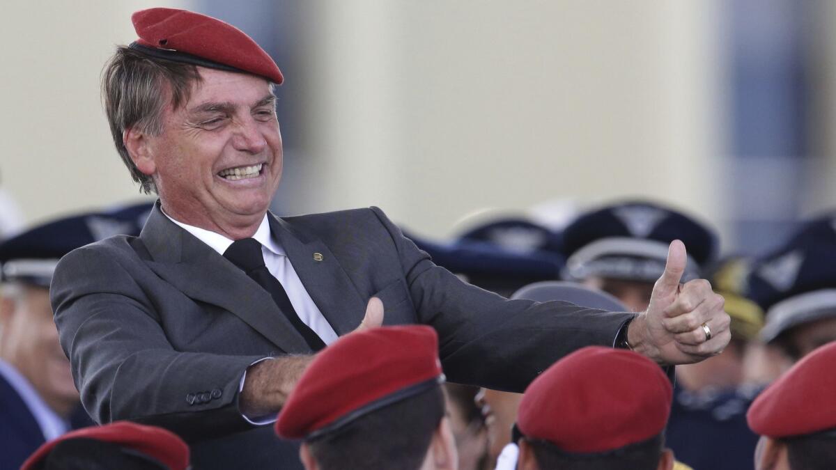 Far-right Brazilian presidential candidate Jair Bolsonaro flashes two thumbs up as he poses for a photo with cadets during a ceremony marking Army Day on April 19, 2018 in Brazil.