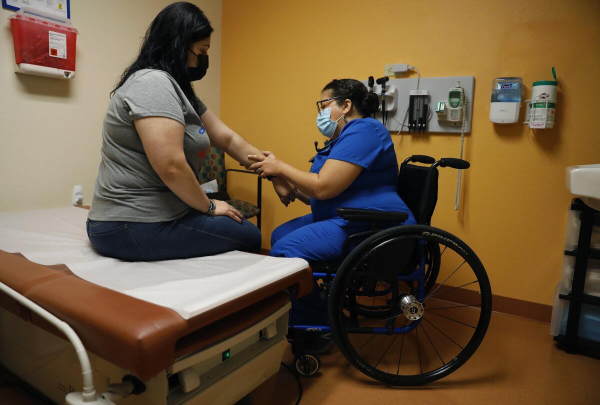 Dr. Marie Flores examines patient Karla Olguin, 35, at the AltaMed clinic in Pico Rivera. 