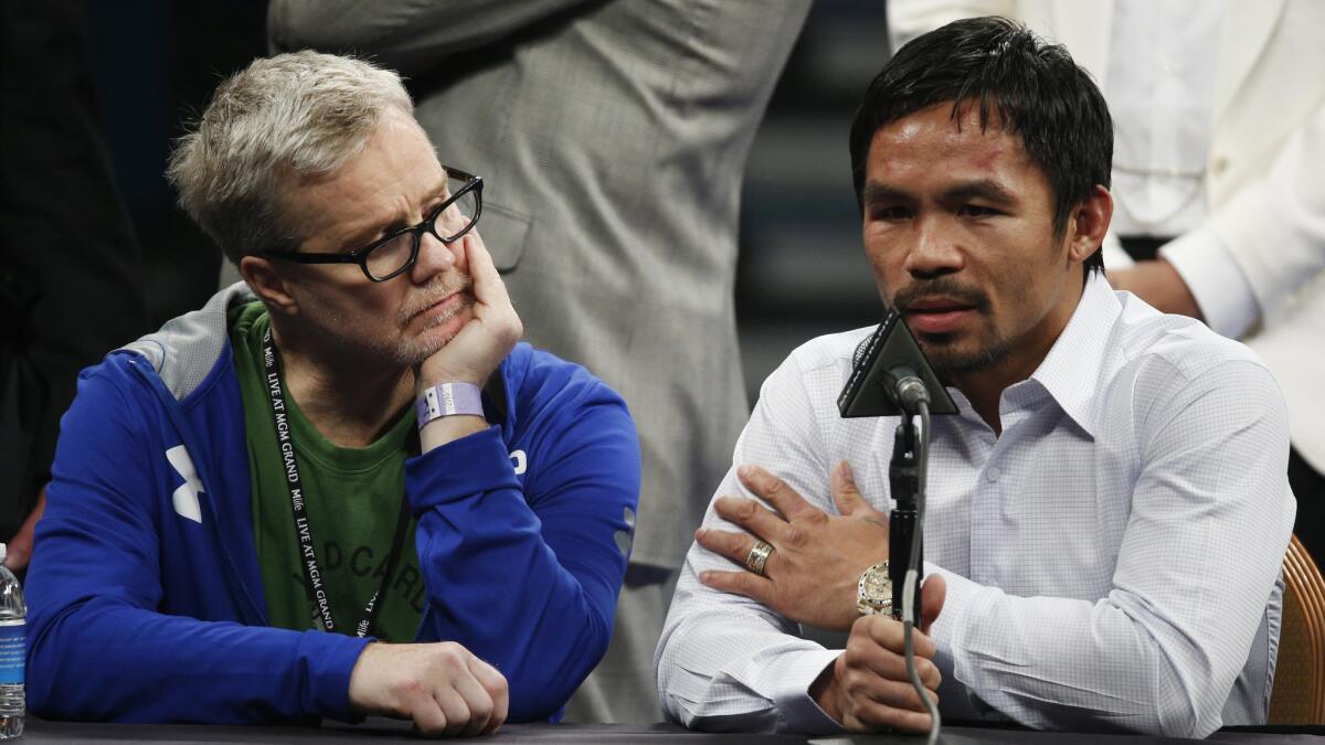 Manny Pacquiao speaks during a news conference Saturday while sitting next to his trainer, Freddie Roach, following his welterweight title loss to Floyd Mayweather Jr.
