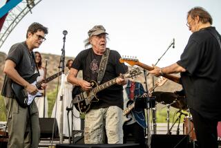 Three musicians with guitars on stage