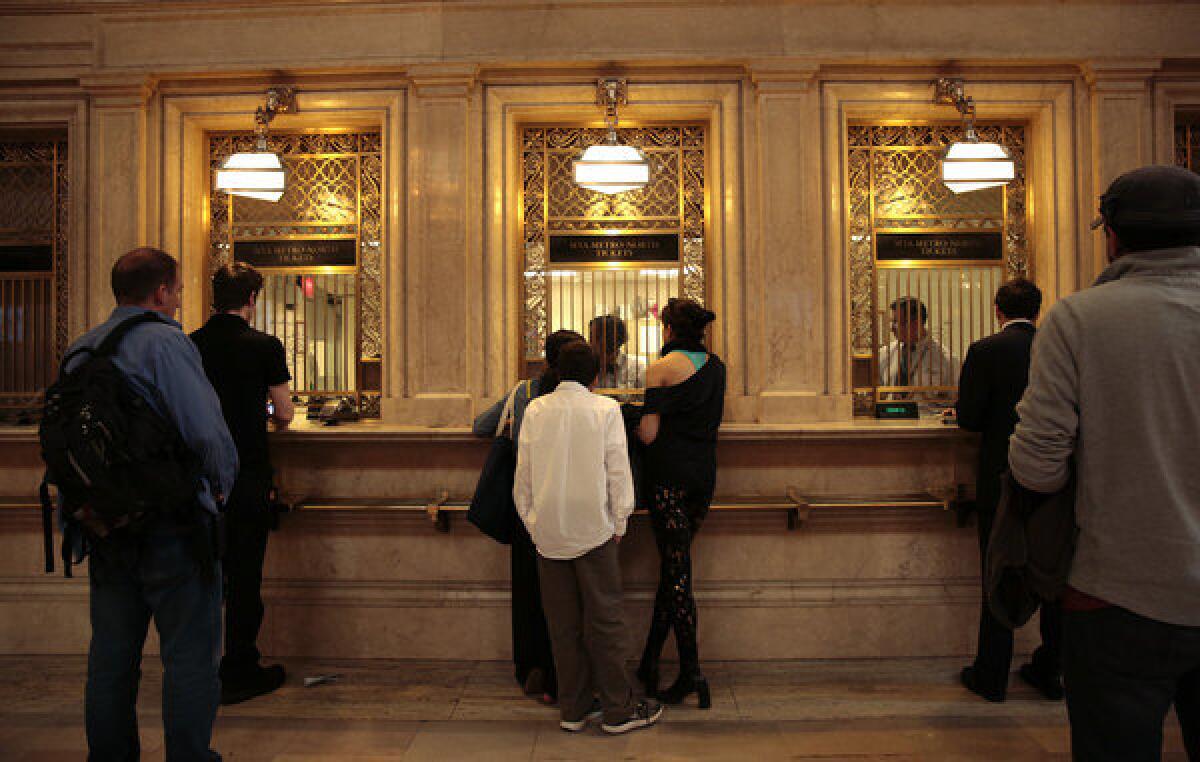 The ticket windows at Grand Central Terminal are framed by ornate brass covers and fixtures.