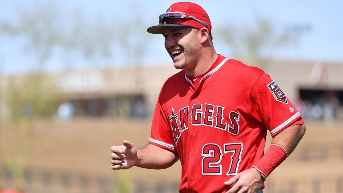 Mike Trout smiles while warming up for a spring training game against the Arizona Diamondbacks.