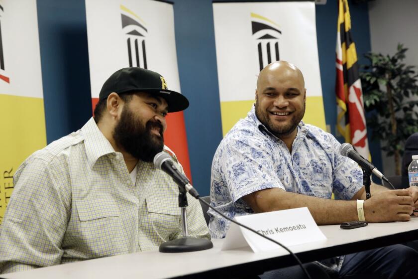 Former Pittsburgh Steeler Chris Kemoeatu, left, and his brother, Ma'ake, speak at a Sept. 17 news conference following their successful kidney transplant surgery.