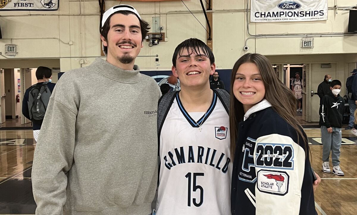 Jaime Jaquez Jr. poses on a basketball court with brother, Marcos, and sister, Gabriela.