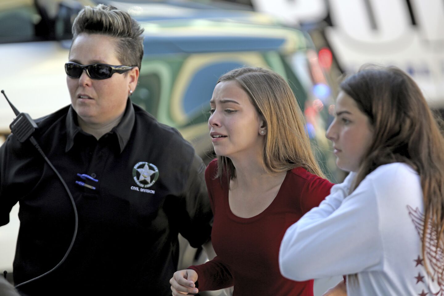 Students are escorted by police following a shooting at Marjory Stoneman Douglas High School in Parkland, Fla.