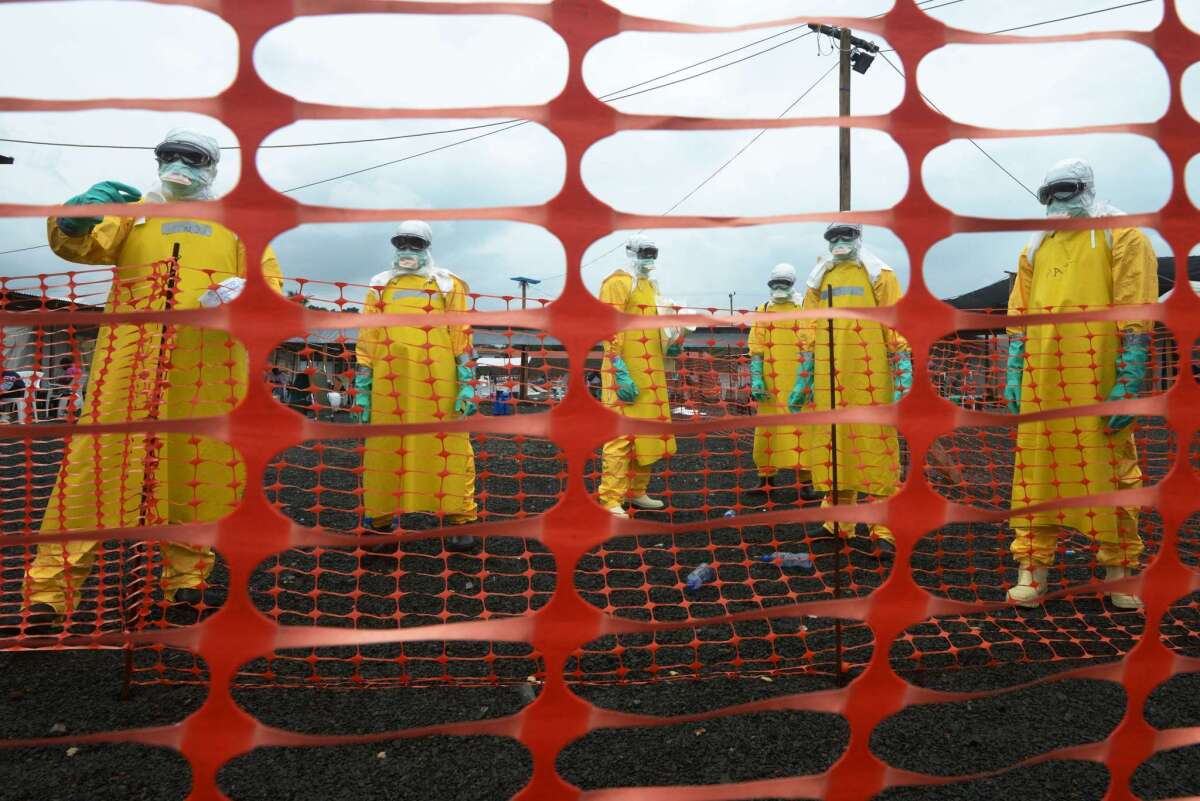 Workers wearing protective gear stand in the contaminated area of an Ebola care facility operated by Doctors Without Borders in the Liberian capital, Monrovia, on Sept. 7.