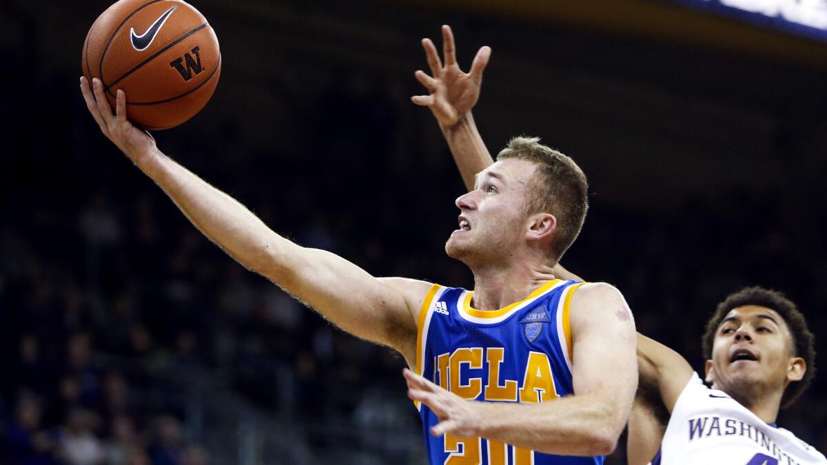 UCLA guard Bryce Alford (20) beats Washington forward Matisse Thybulle (4) for a layup during the first overtime of their game Friday night.