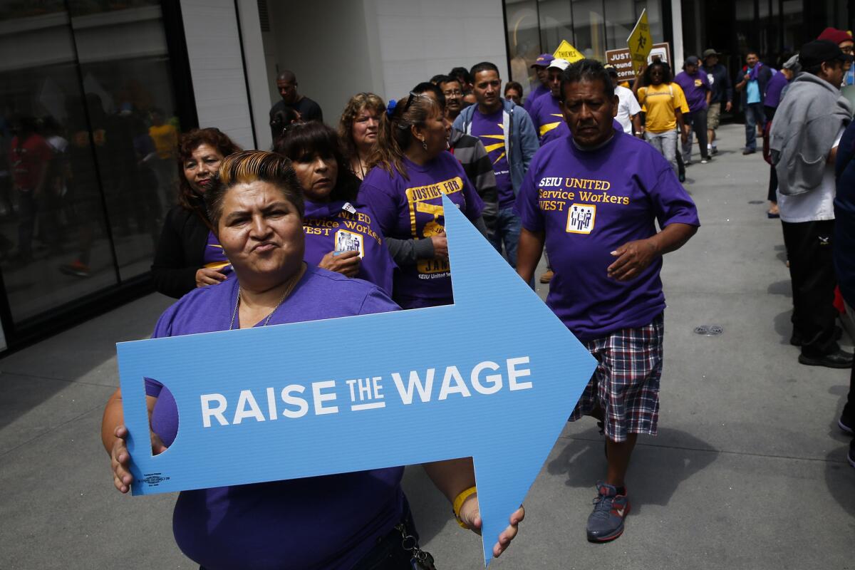 People protest downtown with the Los Angeles Wage Theft and Raise the Wage coalitions in support of a $15 an hour minimum wage Monday in Los Angeles.