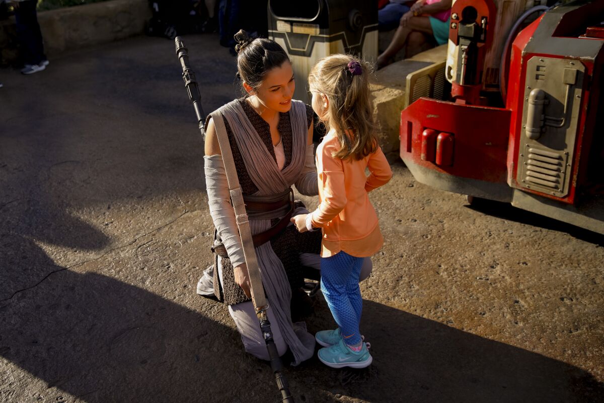 Cast member portraying Rey greets a young visitor at Star Wars: Galaxy’s Edge 