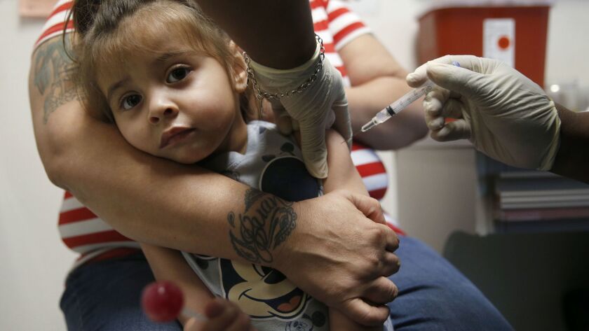 A lollipop and a shot: Karma Islas, 2, gets an immunization vaccine at a clinic in Dallas, where a measles outbreak has spurred efforts to get more children vaccinated.