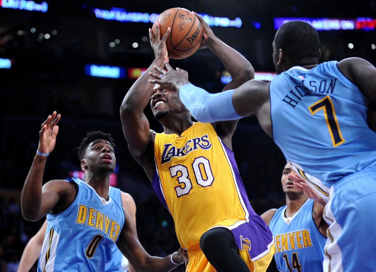 Lakers forward Julius Randle drives between Nuggets Emmanuel Mudiay, left, and J.J. Hickson during the first quarter of a game against Denver at Staples Center on Nov. 3.