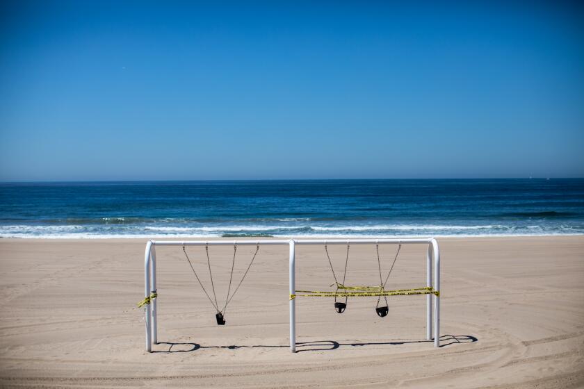 MANHATTAN BEACH, CA - APRIL 24: A swings is locked up and taped off in Manhattan Beach, CA, during the coronavirus pandemic, Friday, April 24, 2020. (Jay L. Clendenin / Los Angeles Times)