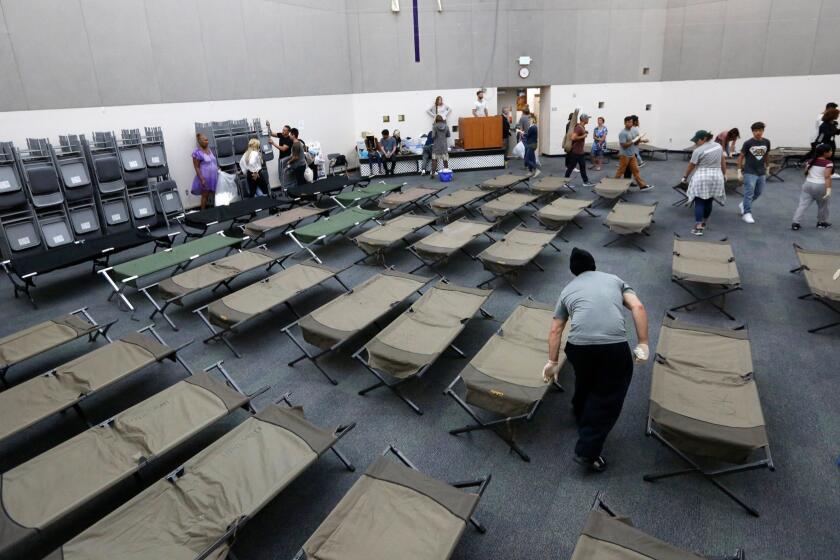 LOS ANGELES, CA - MAY 2, 2017 - Cots are set up for the homeless to sleep on after a church service in the chapel at the Union Rescue Mission on May 2, 2017. The chapel is full of metal chairs during the day and army cots at night. The homeless shelter, designed for 890 people, takes in about 1,300 every night, using the chapel for overflow. (Genaro Molina/Los Angeles Times)