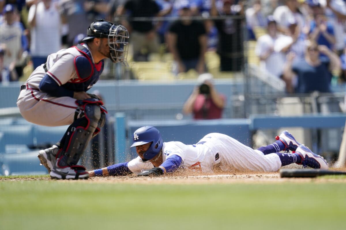 Dodgers' Mookie Betts scores past Atlanta Braves catcher Manny Pina on a single from Justin Turner.