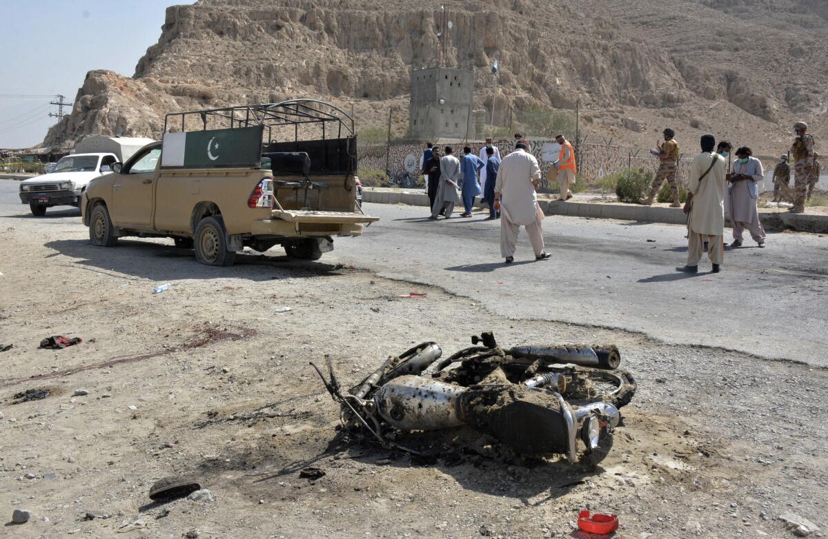 Security officials examine the site of suicide bombing in a checkpoint on the outskirts of Quetta, Pakistan, Sunday, Sept. 5, 2021. A suicide bomber detonated his explosives Sunday near the security checkpoint in restive southwestern Pakistan, killing few paramilitary troops and wounding more than a dozen, police said. (AP Photo/Arshad Butt)