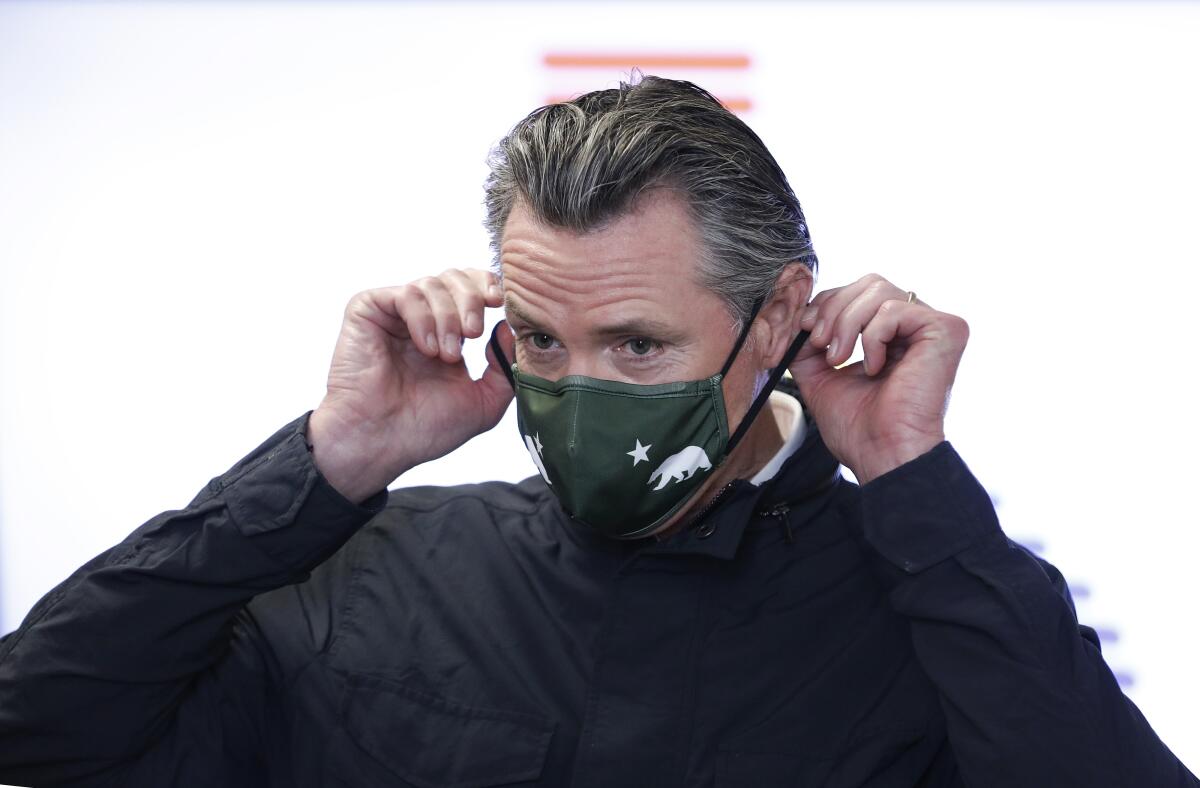 Gov. Gavin Newsom prepares to speak to the media at a COVID-19 vaccination site in South Gate.