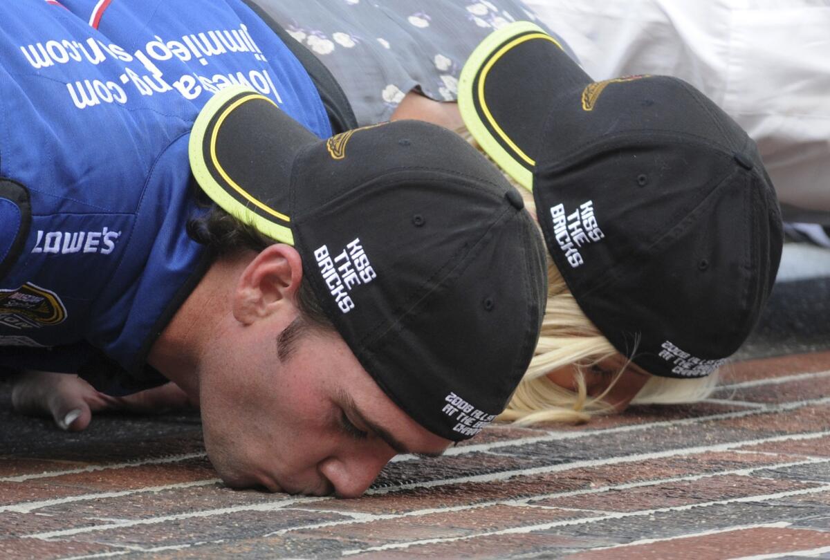NASCAR driver Jimmie Johnson and his wife Chandra kiss the bricks after his Allstate 400 at the Brickyard in 2008. Johnson and his Hendrick Motorsports teammate Jeff Gordon, who have both won the race four times, share the record for most wins at the track.