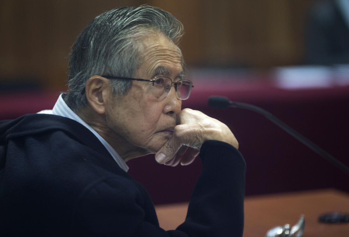 ARCHIVO - El encarcelado expresidente Alberto Fujimori, fotografiado a través de una ventana de vidrio