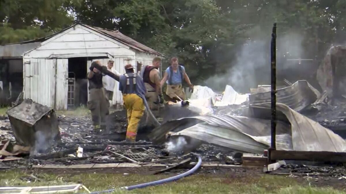 This photo from video by KFVS-TV shows people working the scene of a house explosion in Wyatt Mo., early Monday, Aug. 15, 2022. The house explosion in southeast Missouri has left several people injured and a neighboring home in flames, authorities say. (KFVS TV via AP)