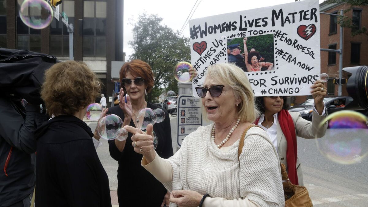 Accuser Victoria Valentino, center, a former Playboy playmate who accused Bill Cosby of slipping her pills and raping her in the late 1960s, appears with a protester Monday in Norristown, Pa.