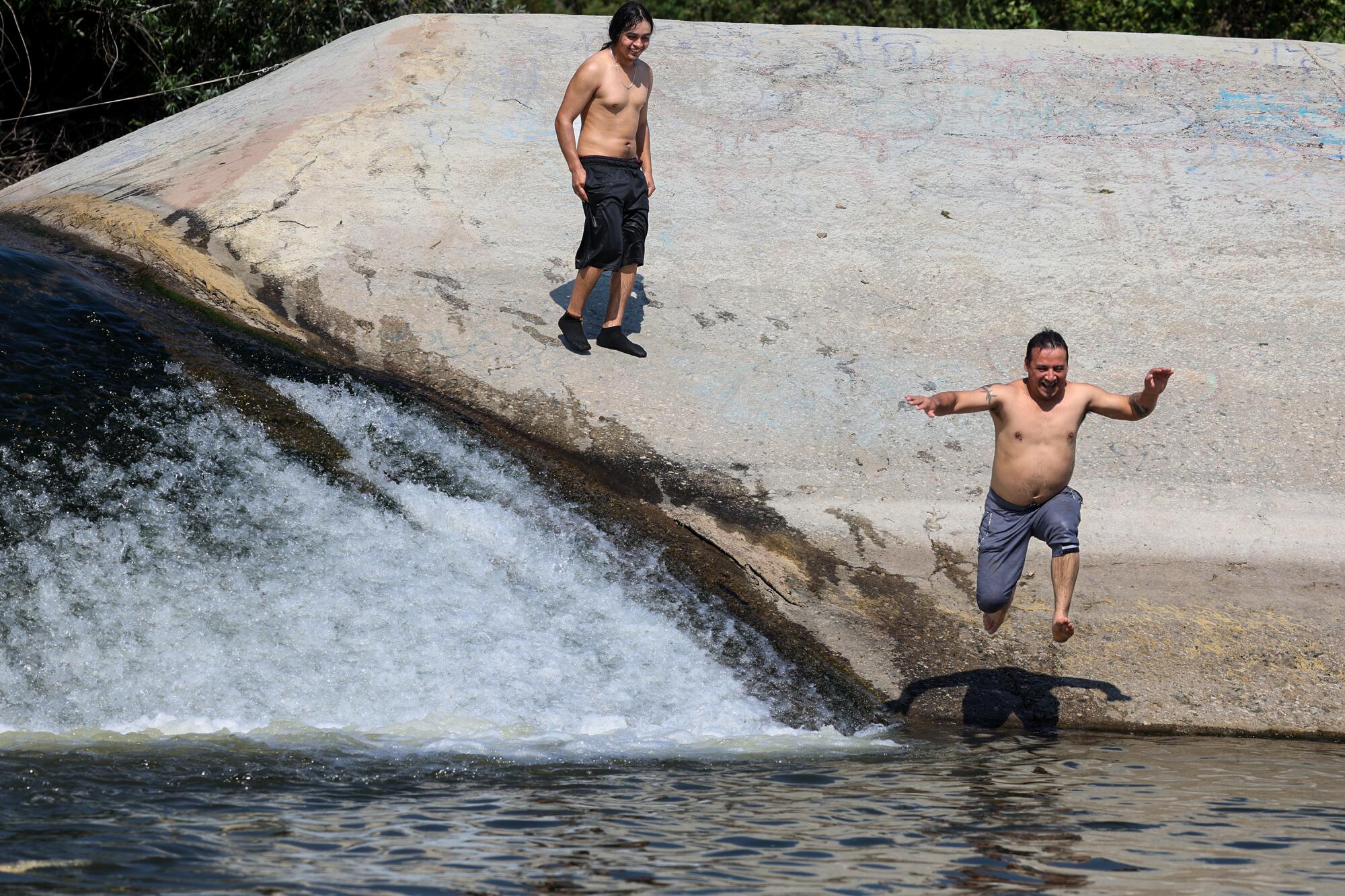 Samuel Chica jumps from a levee wall into the San Gabriel River.