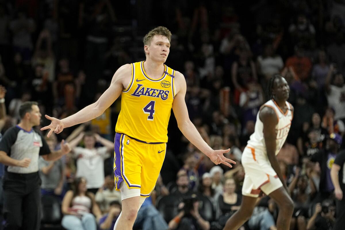 Lakers guard Dalton Knecht celebrates with both arms extended and his fingers signifying three after scoring against Phoenix.