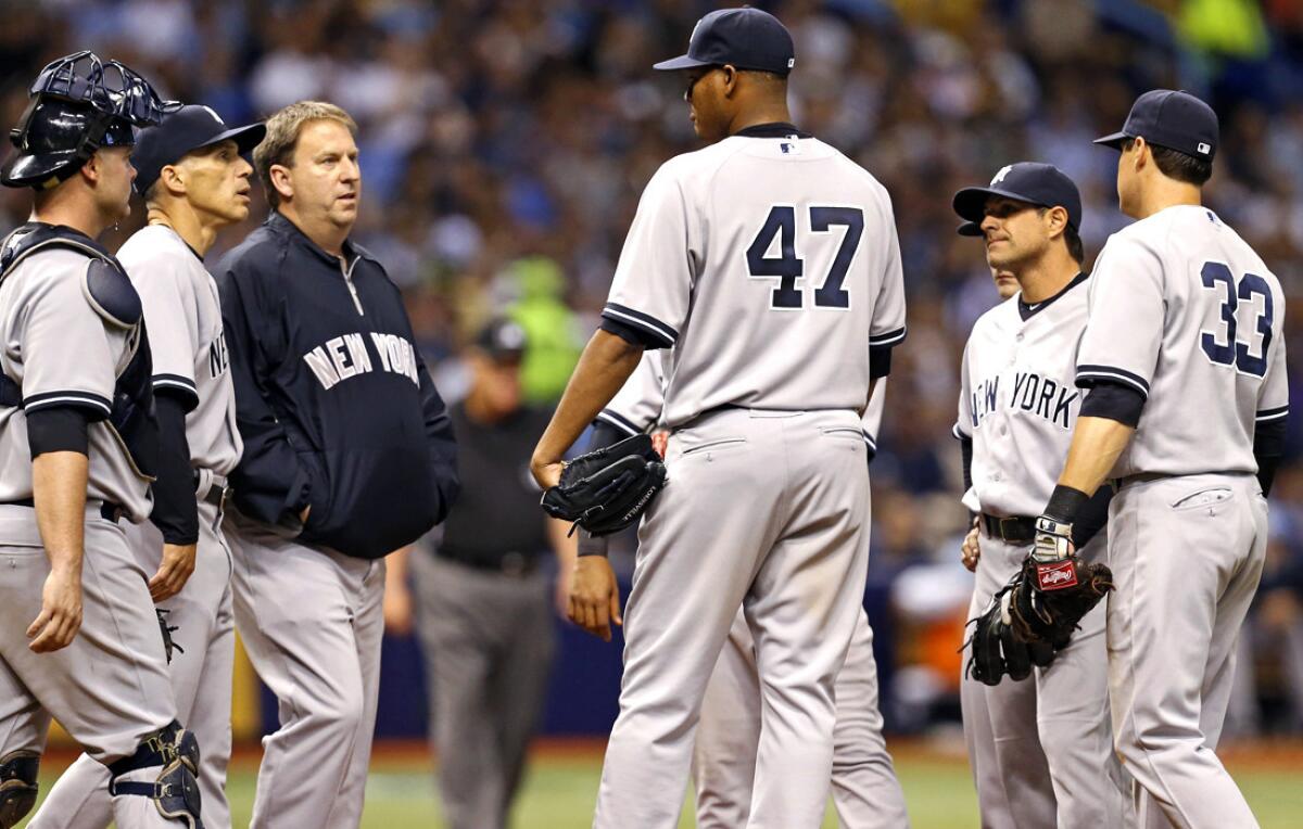 Yankees starting pitcher Ivan Nova (47) is visited on the mound Saturday after injuring his elbow.