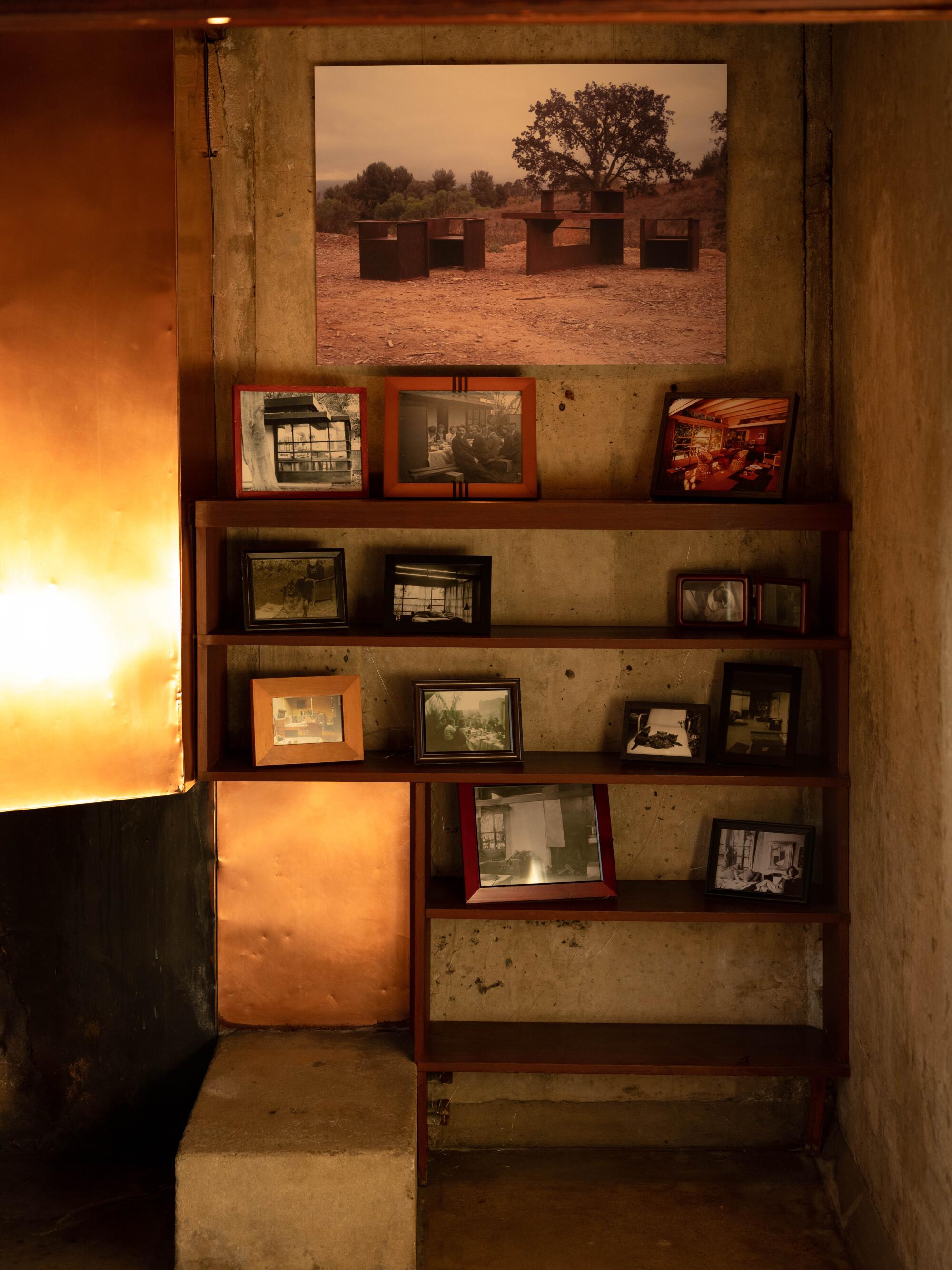 A built-in shelf next to a copper-lined fireplace hood holds rows of framed photos.