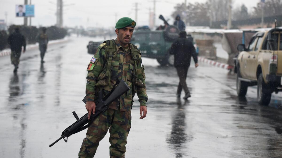 Afghan security personnel stand guard near the site of an attack on the Marshal Fahim National Defense University in Kabul on Jan. 29.