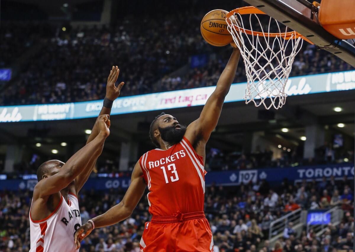 Rockets guard James Harden (13) drives to the basket past Raptors center Bismack Biyombo (8) during the second half.