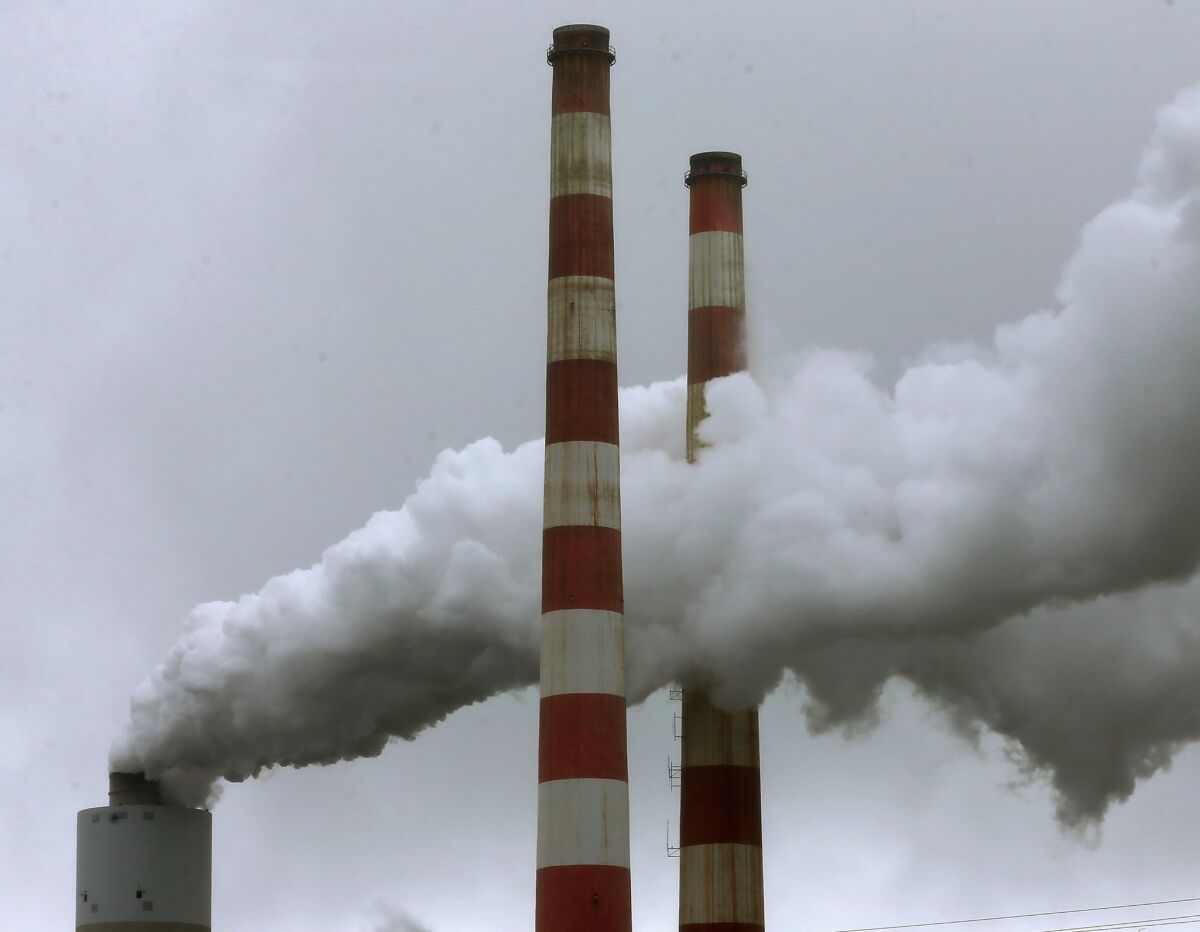 Emissions spew out of a large stack at the coal-fired Morgantown Generating Station in Newburg, Md., on May 29. A new survey found that most Americans support a tax on carbon-fuel emissions if the money is used to promote renewable energy.