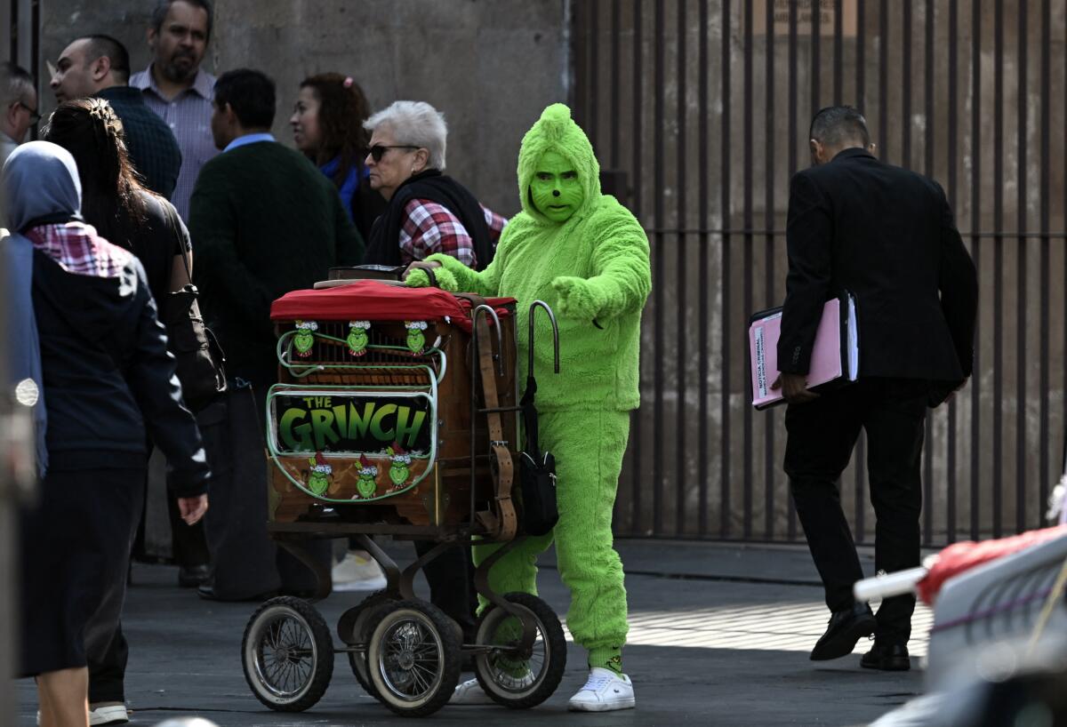 a person dressed as the anti-Christmas character known as the Grinch
