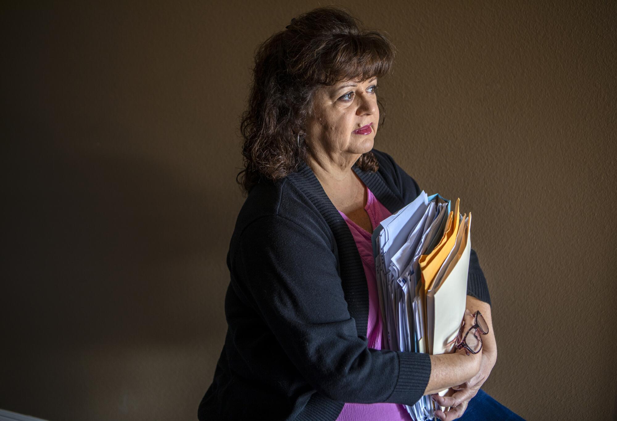 Regina Torrez holding some of her legal documents at her home in Carson, CA. 
