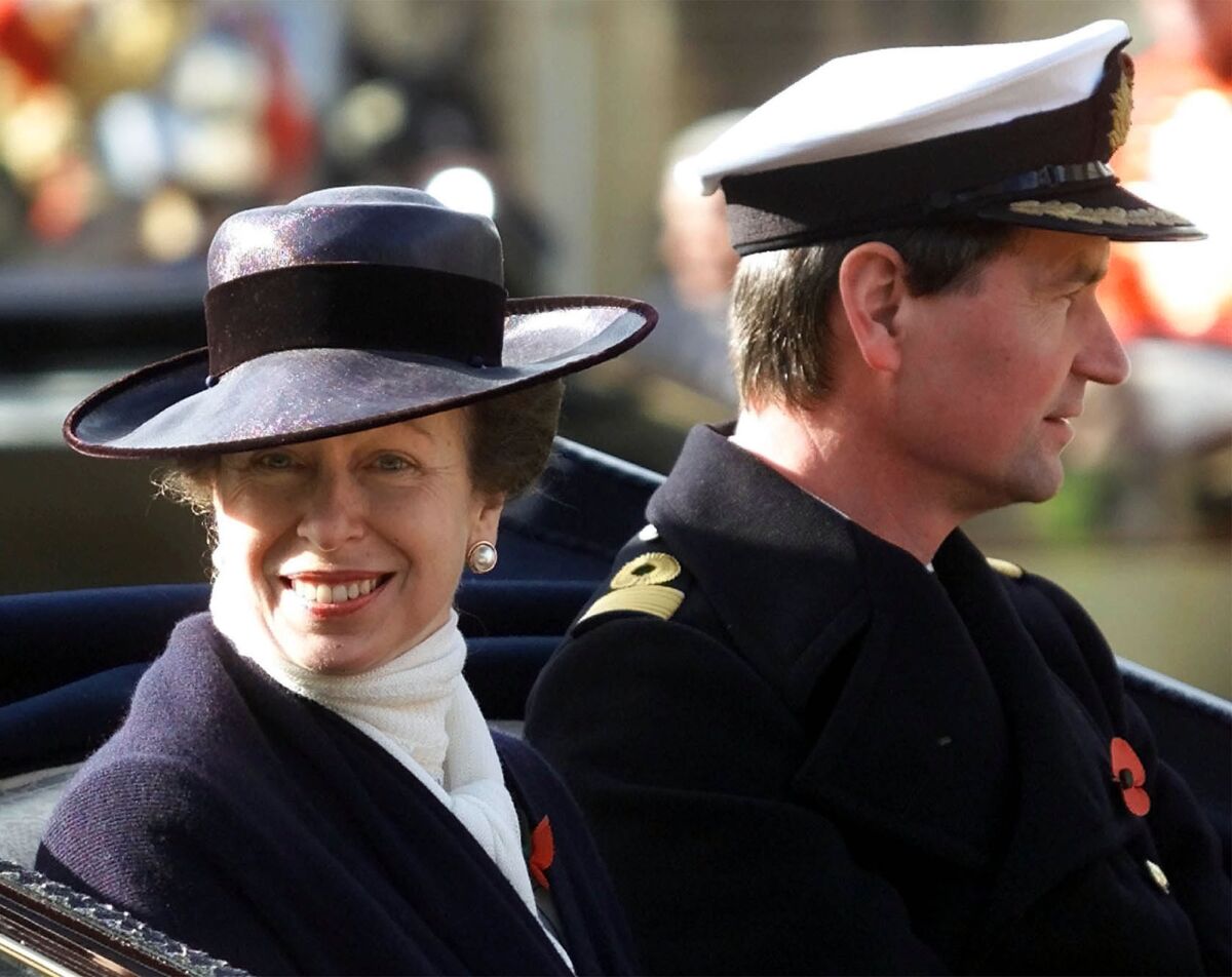 FILE - In this Nov. 6, 2001 file photo, Britain's Princess Anne with her husband Commander Tim Lawrence ride in a ceremonial carriage through Windsor town centre, where they were guests of Queen Elizabeth II at Windsor Castle to welcome King Abdullah and Queen Rania of Jordan on their state visit to England. Queen Elizabeth II’s only daughter, Princess Anne, will be celebrating her 70th birthday on Saturday, Aug. 15, 2020 in a no-nonsense manner that befits her reputation in Britain. Whatever is planned for Saturday, it’s certainly going to be a scaled-back affair because of the coronavirus pandemic. (AP Photo/Dave Caulkin/File)