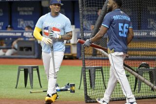 Wander Franco, izquierda, de los Rays de Tampa Bay, y Vidal Brujan, quien porta un jersey de Arozarena, cambian posiciones durante una sesión de práctica de bateo antes del partido en contra de los Reales de Kansas City, el sábado 24 de junio de 2023, en San Petersburgo, Florida. Franco regresa a la alineación después de haber sido mandado a la banda por dos partidos. (AP Foto/Steve Nesius)