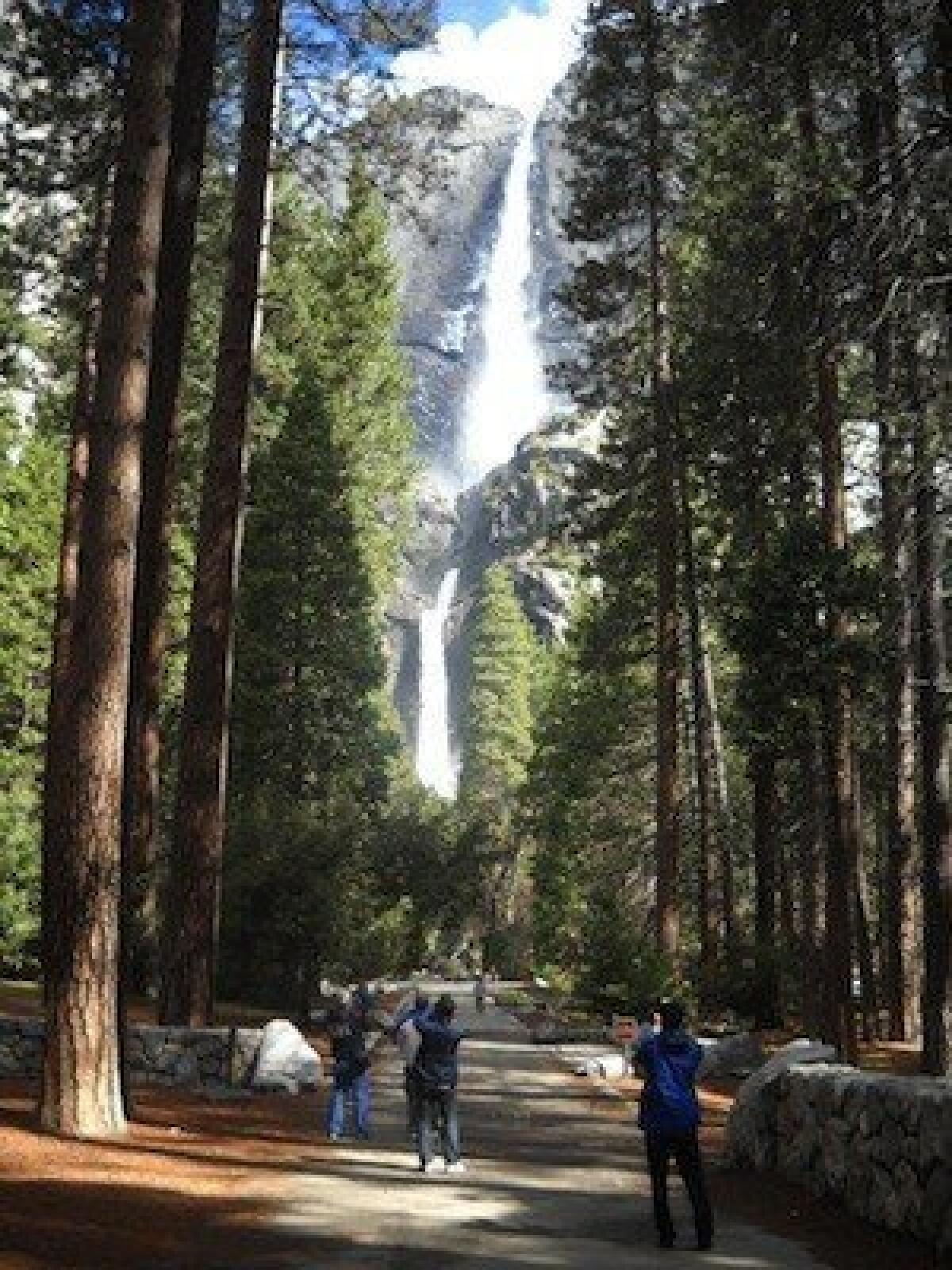 Tourists snap photos of Yosemite Falls last month. Despite the water works, the park is experiencing higher than usual fire danger for this time of year.