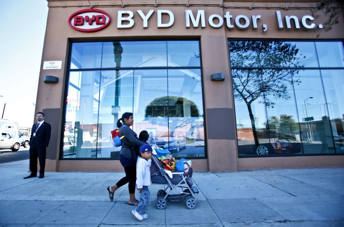 Pedestrians walk past BYD's U.S. headquarters in downtown Los Angeles.
