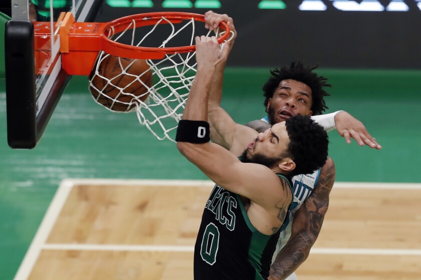 Boston Celtics' Jayson Tatum (0) dunks against Charlotte Hornets' Miles Bridges during the first half of an NBA basketball game, Sunday, April 4, 2021, in Boston. (AP Photo/Michael Dwyer)