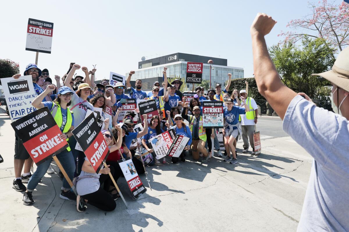 Members of Writers Guild of America cheer at the end of their picket in front of CBS Television City