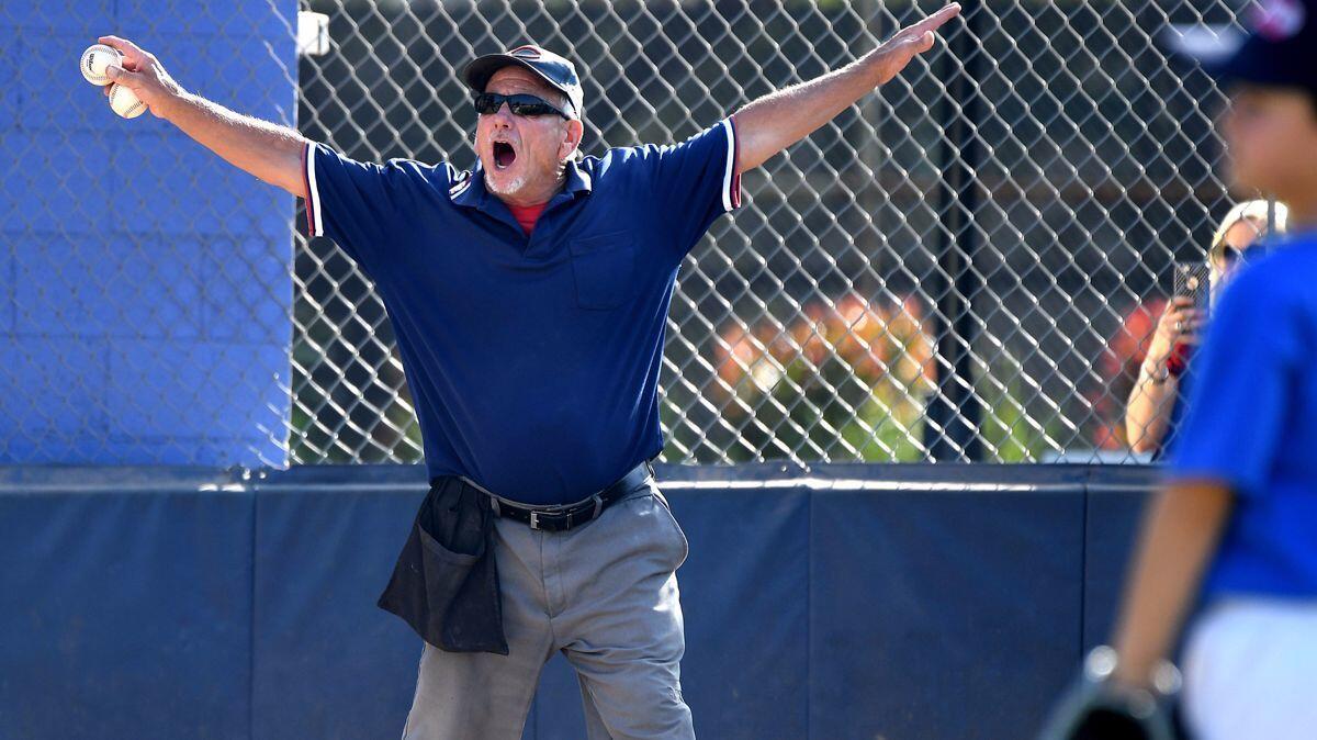 Umpire Pete Constantino calls a play at home plate during a Southwest Pasadena little league game. Constantino has been an umpire for 40 years.