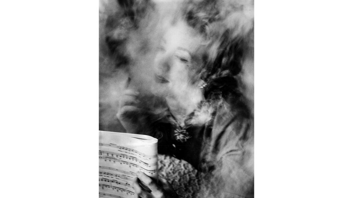 Marni Nixon sits in a haze and holds sheet music