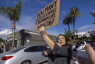 Los Angeles, CA - November 16: Volunteer organizer Elizabeth Fernandez holds a sign as a push to unionize Starbucks workers continues in front of a Starbucks store on Glendale Blvd. on Thursday, Nov. 16, 2023 in Los Angeles, CA. (Brian van der Brug / Los Angeles Times)