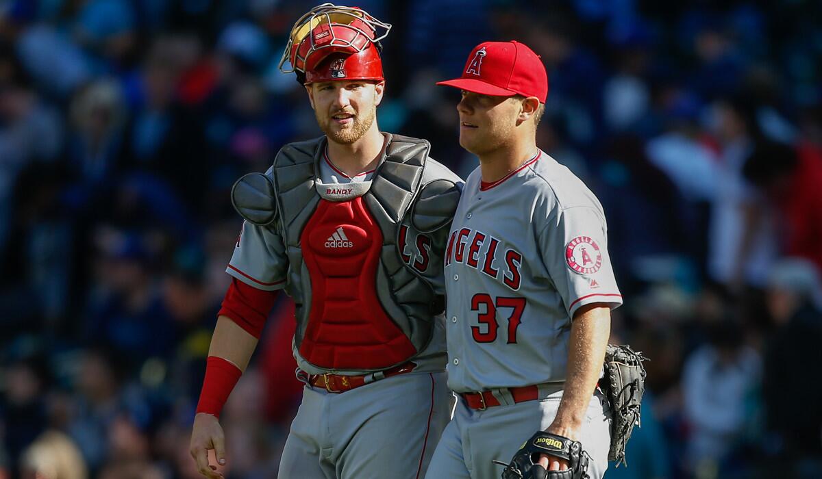 Angels relief pitcher Andrew Bailey, right, is congratulated by catcher Jett Bandy after beating the Seattle Mariners, 4-2, Sunday.