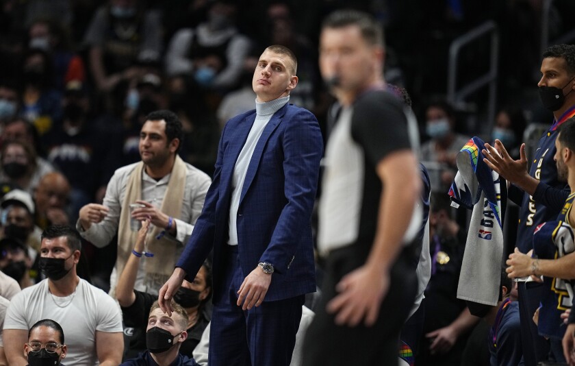Denver Nuggets center Nikola Jokic (15) looks on from the bench against the Milwaukee Bucks during the second quarter of an NBA basketball game Friday, Nov. 26, 2021, in Denver. (AP Photo/Jack Dempsey)