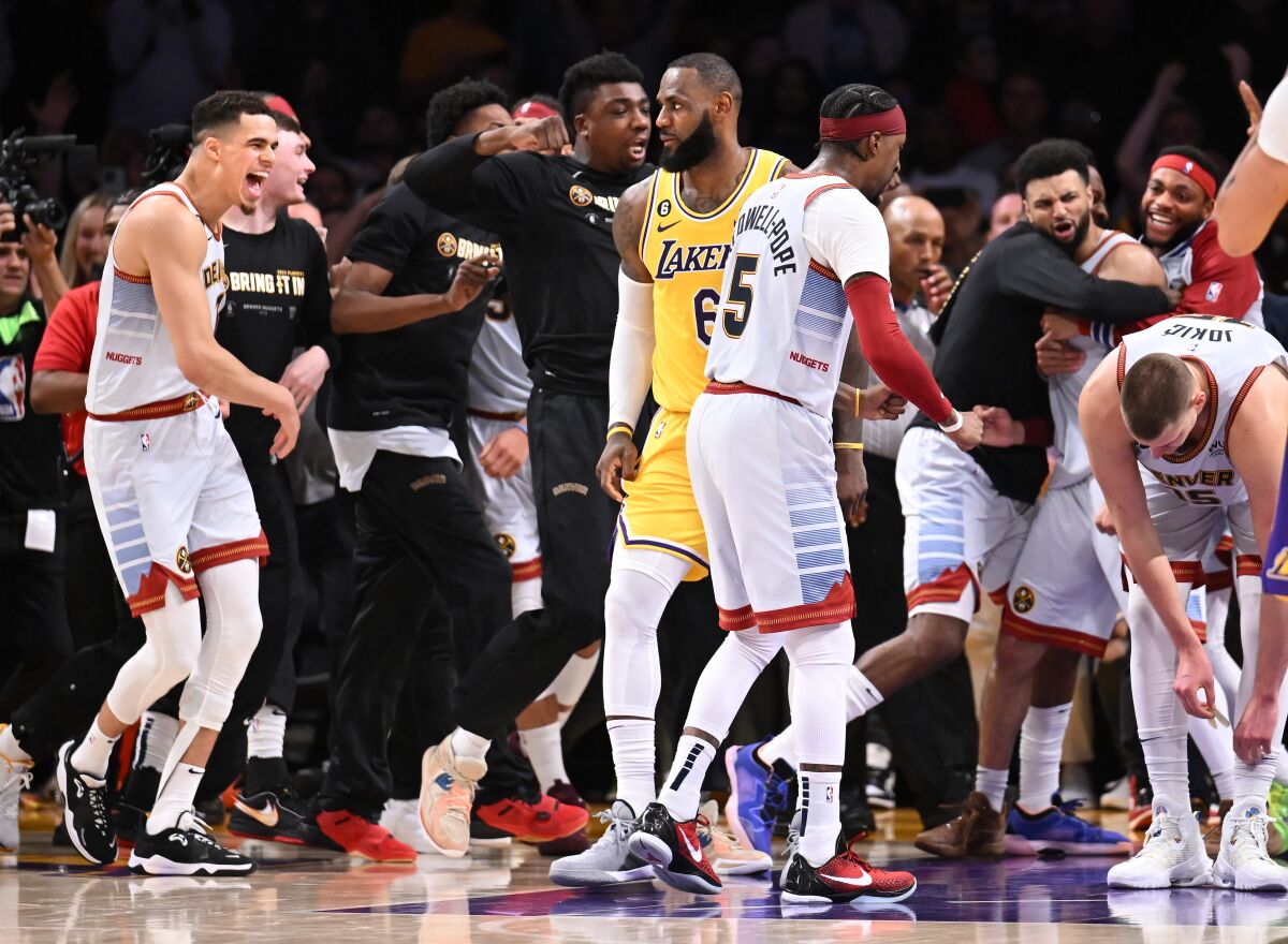 Lakers star LeBron James walks off the court as the Denver Nuggets celebrate.